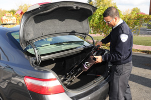 Photo of a driver putting a wheelchair in the trunk of the taxi
